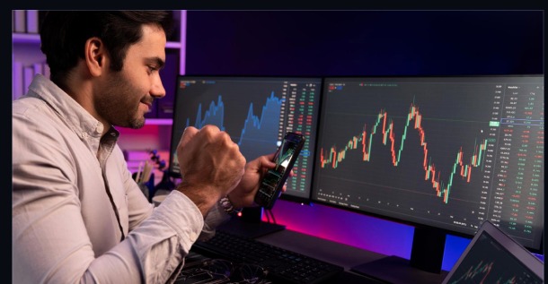 Trader analyzing charts on multiple screens